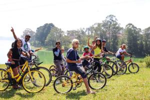 Crianças e adolescentes do Jardim Gaivotas se reúnem com suas bicicletas na margem gramada da represa Billings durante uma atividade do projeto Bikes Marginais. Coordenado pelo Coletivo Imargem, o percurso une lazer, mobilidade e educação ambiental, transformando as pedaladas em uma forma de explorar, reconhecer e valorizar a paisagem natural do Grajaú.