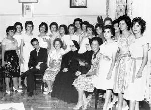 Juvenal (único professor do sexo masculino entre professoras e alunas) na cerimônia de formatura do Curso Normal do Colégio do Sagrado Coração de Jesus. Na foto, de pé as alunas e sentados, Juvenal, a Madre Superiora Lucília Suruggi, irmã Rosália Motter e a Professora Terezinha Bertoni.