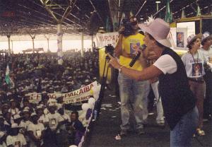 Rejane no palco como presidente da CUT DF em fala na abertura da primeira Marcha das Margaridas, no pavilhão do Parque da Cidade. Rejane disse: “Tinha 30 mil mulheres, foi lindo”.