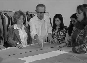 Cena de aula do curso Sentir e Vestir a Moda com as alunas com deficiência visual: Maria Regina, Maria Rita, Bárbara e Ana Cláudia. Elas manuseiam moldes de peças de roupa.