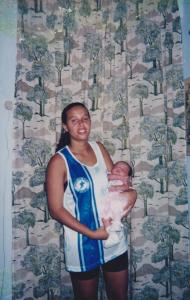 Mãe do ely com sua irmã nos braços com a blusa da mancha azul.