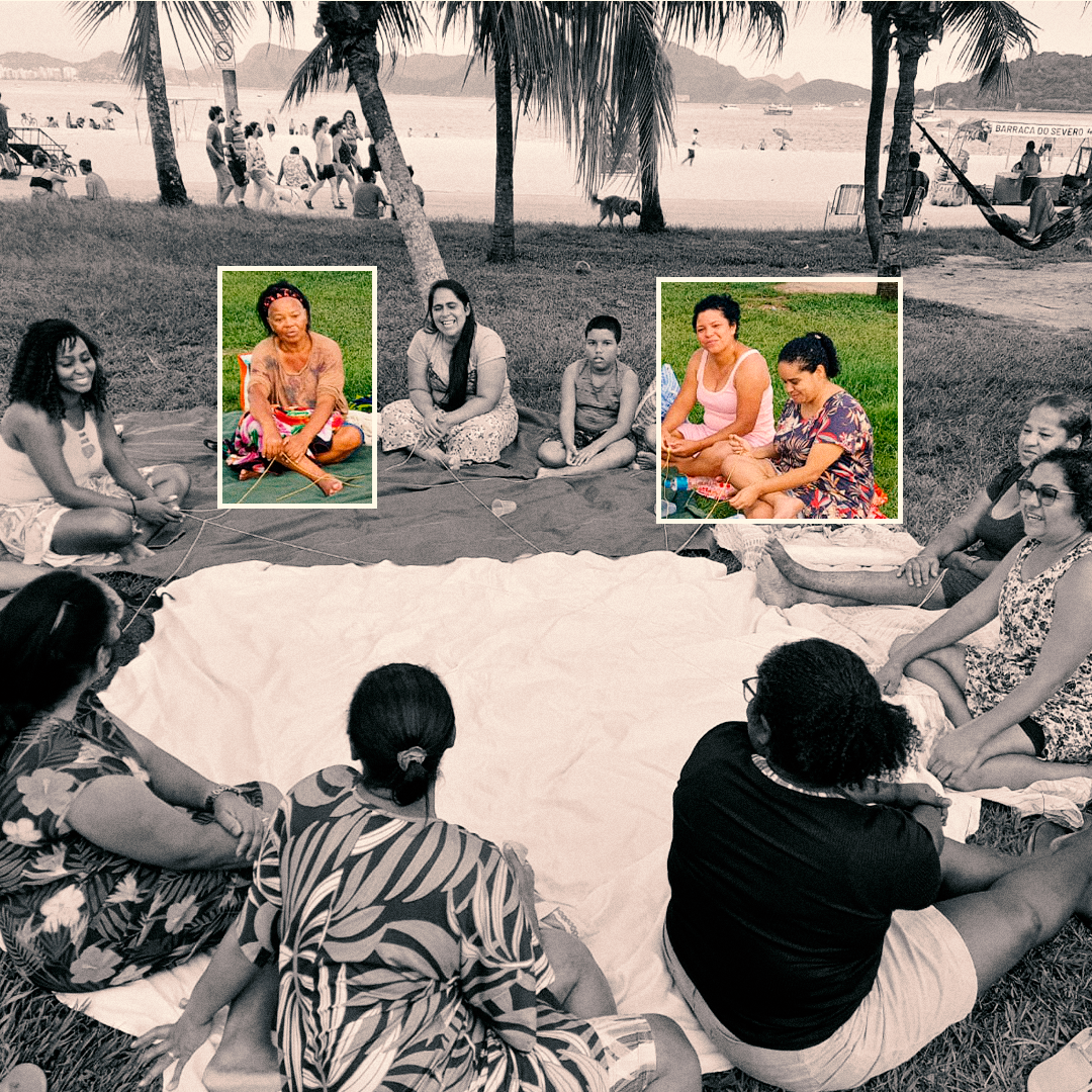 Fotografia em preto e branco. Um grupo de mulheres e uma criança estão sentados em círculo no chão, com as pernas cruzadas. Elas estão em cima de lençóis em uma grama. Atrás, há areia, mar, coqueiros e algumas pessoas andando. Há dois quadrados transparentes, com margem branca, que está preenchido por cores que revelam a segunda mulher do grupo, com o cabelo para trás preto, usa uma blusa marrom e bermuda estampada de várias cores. O segundo quadrado, foca na quinta e sexta mulheres do grupo. A quinta, veste um vestido rosa e tem cabelos pretos curto, e a sexta, ao seu lado, usa um vestido estampado azul e tem os cabelos pretos presos em um rabo de cavalo no alto.